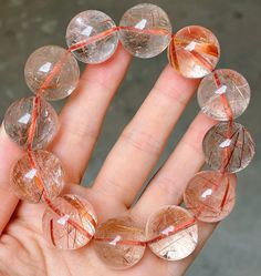 a hand is holding several clear glass beads