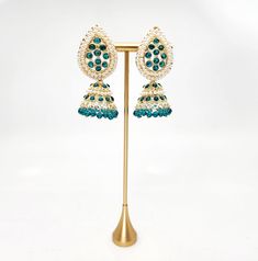 Embrace the traditional charm of our Radha Jhumka Earrings in a beautiful teal and aqua color palette. Made with lightweight materials, these earrings are soft and easy to wear, perfect for adding a touch tradition any mehndi, sangeet or garba event. Don't miss out on these stunning pearl adorned jhumkas! Green Latkan Bridal Earrings For Diwali, Green Latkans Bridal Earrings For Diwali, Green Bridal Earrings With Latkans For Diwali, Turquoise Chandbali Earrings Bollywood Style, Turquoise Chandbali Bollywood Earrings, Green Dangle Jhumkas For Festive Occasions, Traditional Turquoise Earrings For Wedding, Turquoise Earrings For Wedding And Festivals, Green Bridal Earrings With Latkans For Celebration