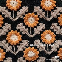 a crocheted blanket with orange and white flowers