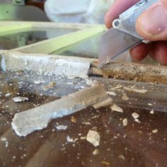 a person using a pair of scissors to cut wood