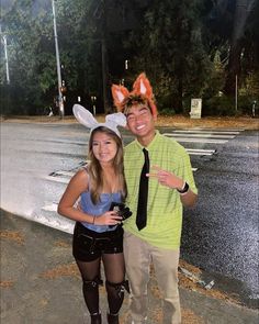 a man and woman dressed up in bunny ears posing for a photo on the street