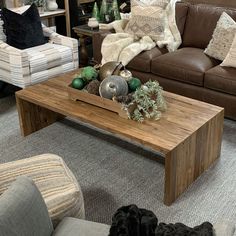 a living room filled with lots of furniture and pillows on top of it's wooden coffee table