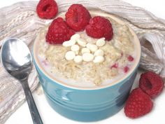 a bowl of oatmeal with raspberries and marshmallows