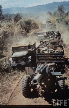 several jeeps are lined up on the side of a dirt road