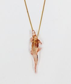 a gold necklace with an image of a woman wearing a dress on it's back