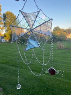 a wind chime hanging from the side of a green field