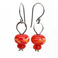 "These red earrings feature four colorful poppy red beads that I handmade in my studio.  The lampwork beads have been stacked and wire wrapped using sterling silver wire.  Bright, colorful, and beautiful! Handmade Red Lampwork Glass Beads 1.5\" L x .5\" W 925 Sterling Silver Findings and Ear Wires Comes in a signature kraft jewelry box ready for gifting ~ About Me: My name is Kathy Bankston, and I am a metalsmith and lampwork bead maker. All my items are completely handmade by me from start to finish. I do everything, from designing and sketching, to sawing every little piece out with a hand saw, filing and shaping, and soldering it all together. My glass beads are made from Effetre soda glass and are kiln annealed in my studio. Many of my items are one of a kind, only a few are designs th Gift Red Beaded Earrings With Ear Wire, Red Drop Beaded Earrings As Gift, Red Beaded Drop Earrings As Gift, Red Dangle Earrings With Colorful Beads, Unique Handmade Red Earrings, Vibrant Red Earrings For Gift, Red Czech Glass Beaded Earrings With Dangling Beads, Red Czech Glass Earrings With Dangling Beads, Adjustable Red Czech Glass Beaded Earrings