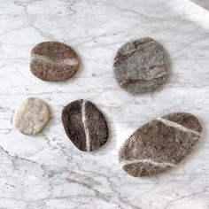 four rocks sitting on top of a white marble counter