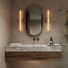 a bathroom with a sink, mirror and lights on the wall next to each other