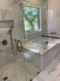 a bath room with a walk in shower next to a tub and a sink under a window