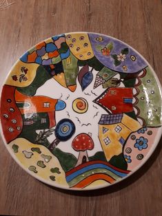 a colorful plate sitting on top of a wooden table