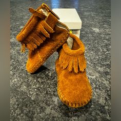 Minnetonka Pa-Poo-Shu Infant Size 2 Brown Style 1182 100% Leather Never Been Used Contemporary Style: Designed With A Stylish Bootie Silhouette, These Baby Fringe Moccasins Are Made With The Finest Materials That Provide Comfort, Durability, And Timeless Style With Every Step Cozy Shoe Fit: The Infant Moccasin Booties Are Made To Stretch To The Contours Of Baby's Feet And Wear Pattern Over Time, Ensuring That Each Pair Of Suede Moccasins Fit Snugly And Getting More Comfortable As They Wear Them Casual Moccasins With Round Toe For Playtime, Casual Round Toe Moccasins For Playtime, Casual Round Toe Moccasins, Fall Soft Sole Closed Toe Booties, Fall Booties With Soft Sole And Round Toe, Toddler Moccasins, Fringe Moccasins, Cozy Shoes, Fringe Fashion