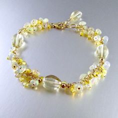 "This fresh lemon yellow quartz bracelet is paired up with Ethiopian opals that has a slight yellow cast to them. I have also sprinkled in sparkling yellow zircon rounds. All gold filled components are used. The lemon quartz measure approximately 12x9mm. The opals measure 5mm. and the zircon measure 2.5mm. The bracelet measures 7 1/2\" in length 9not including the extender chain) and will fit wrists from 6 3/4\" to 7 1/2\" comfortably." Elegant Gold Citrine Crystal Bracelet, Gold Beaded Bracelets With Gemstone Accents, Elegant Yellow Crystal Bracelet With Round Beads, Elegant Yellow Bracelets With Gemstone Beads, Elegant Yellow Gemstone Beads Bracelets, Elegant Yellow Beaded Bracelets With Gemstone Beads, Elegant Yellow Gemstone Beaded Bracelets, Yellow Citrine Gemstone Bracelets, Yellow Citrine Jewelry With Stones