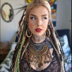 a mannequin with dreadlocks and tattoos on her chest is shown in front of a bed