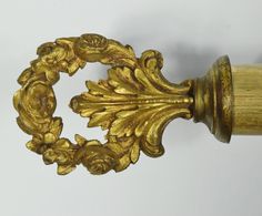 an ornate wooden handle with gold paint on it