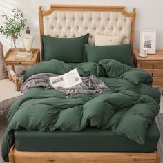 a bed with green sheets and pillows in a room