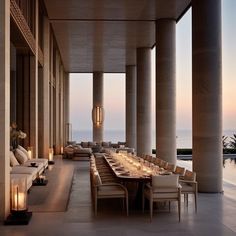 an outdoor dining area with large columns and tables set up for dinner at the end