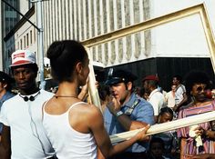 a man holding a baseball bat in front of a group of people on the street