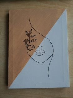 a piece of paper with a drawing of a woman's face and leaves on it