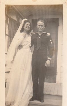 an old black and white photo of a man and woman in wedding attire standing on steps