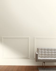 a white couch sitting in front of a wall