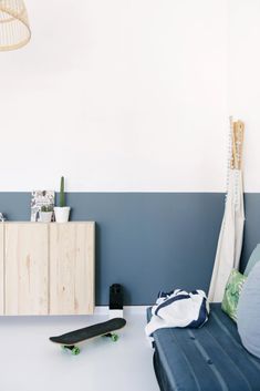 a skateboard is sitting on the floor in front of a blue couch and white wall