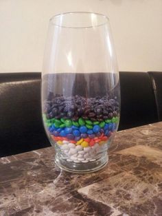 a glass filled with lots of candy sitting on top of a table