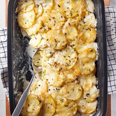 a casserole dish with potatoes and herbs in it, ready to be eaten