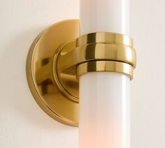 a close up of a light on a wall with a white candle in the corner