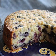 a blueberry cake is cut into pieces on a plate