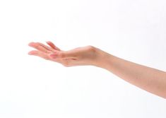 a woman's hand reaching out to catch something with her right hand, against a white background