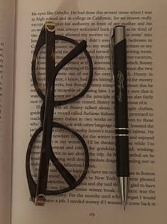 an open book with glasses, pen and eyeglasses on it