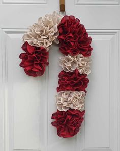 a wreath made out of fabric flowers on the front door