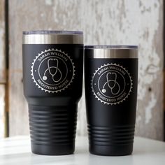 two black tumblers sitting on top of a table