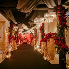 an aisle decorated with red flowers and candles