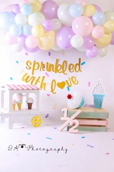 a birthday party with balloons and confetti on the wall, including an ice cream cart