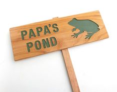 a wooden sign that says papa's pond with a frog on it