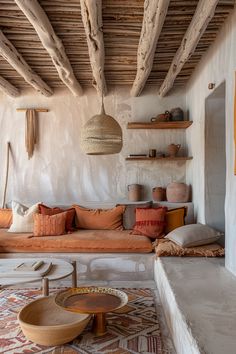 a living room filled with lots of furniture next to a stone wall and wooden beams