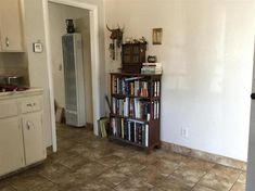 a kitchen with a book shelf filled with books