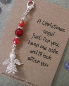 a christmas angel keychain with red and white beads on it's side