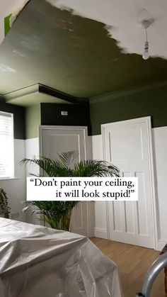 a bedroom with green walls and white trim on the ceiling has a quote above it