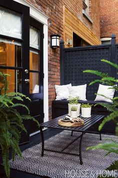 an outdoor patio with black furniture and plants