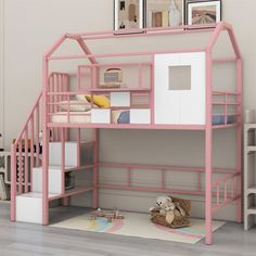 a pink bunk bed sitting on top of a wooden floor next to a white wall