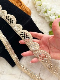 a woman's hand is holding two tiaras