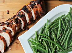 meat and green beans on a white plate