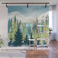 a wall mural with mountains and trees painted on it in an office space, next to a ladder