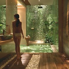 a woman in a bathing suit is walking into a bathroom with green walls and wood flooring