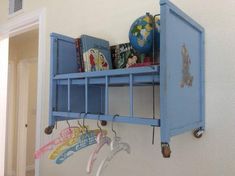 a blue shelf with some books on top of it and other items hanging from hooks