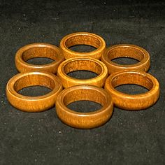 six wooden rings sitting on top of a black surface