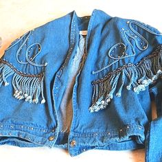 Vintage Denim Jacket From "Store" Cache,, With Metal Studs Detail And Rope Fringes.....Beautiful Jacket.... Front Has Black Stripe With Small Curly Metal Ribbon In Center Of Black Stripe Has 2 Removable Shoulder Pads Bottom Snap Closure Very Soft Denim Material Really Beautiful Detail Thru- Out Made In U.S A. Size Xs.....Extra Small Rope Design Has Metal Studs All Along Rope. Hanging Rope Fringes Match The Rope Design They Hang Loosely From Front And Shoulders Back Of Jacket Same Design Pattern. Festival Denim Fringe Outerwear, Blue Denim Jacket With Fringe, Denim Blue Jacket For Fall Festival, Festival Medium Wash Denim Outerwear, Fitted Denim Outerwear For Festival, Spring Rodeo Dark Wash Denim Jacket, Fitted Denim Blue Denim Jacket For Festival, Festival Denim Jacket, Unique Denim Jacket